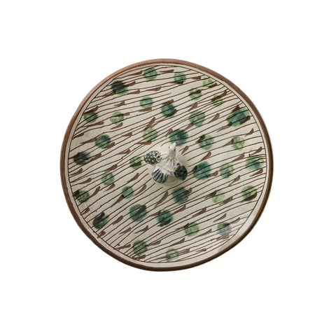 Ceramic plate with decorative pattern on a beige background