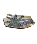 Ceramic tray with leaf pattern on a beige background